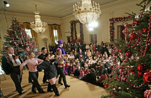 President George W. Bush and Mrs. Laura Bush sit with children of deployed U.S. military personnel and watch a performance of "Willy Wonka" by members of The Kennedy Center Education Department in the East Room Monday, Dec. 4, 2006. White House photo by Eric Draper