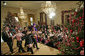 President George W. Bush and Mrs. Laura Bush sit with children of deployed U.S. military personnel and watch a performance of "Willy Wonka" by members of The Kennedy Center Education Department in the East Room Monday, Dec. 4, 2006. White House photo by Eric Draper