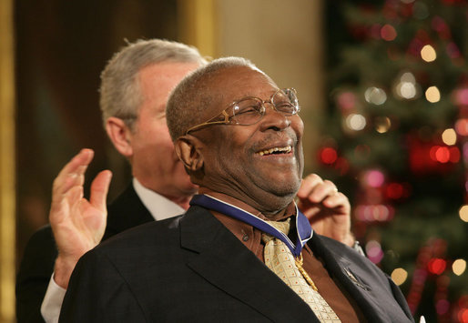 B.B. King breaks out in laughter as he's presented with the Presidential Medal of Freedom Friday, Dec. 15, 2006, by President George W. Bush in the East Room of the White House. Introducing the musician, President Bush told the audience, when speaking of the blues, "two names are paramount. B.B. King, and his guitar, Lucille. America loves the music of B.B. King, and America loves the man, himself." White House photo by Shealah Craighead