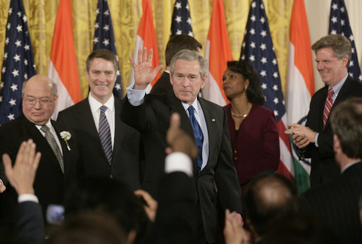 President George W. Bush acknowledges the applause of invited guests after signing H.R. 5682 The United States-India Peaceful Atomic Cooperation Act, Monday, Dec. 18, 2006, in the East Room of the White House. H.R. 5682 will allow the U.S. and India to share civilian nuclear technology and bring India’s civilian nuclear program under the safeguards of the International Atomic Energy Agency. White House photo by Kimberlee Hewitt