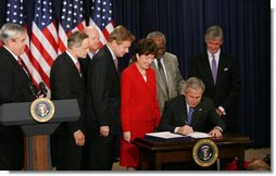 President George W. Bush signs H.R. 6407, the Postal Accountability and Enhancement Act, Wednesday, Dec. 20, 2006, at the Eisenhower Executive Office Building in Washington, D.C., joined by, from left to right, Postmaster General Jack Potter, Sen. Thomas Carper of Delaware, James C. Miller III, Chairman of the Postal Service Board of Governors; Rep. Tom Davis of Virginia, Sen. Susan Collins of Maine, Rep. Danny Davis of Illinois and Rep. John McHugh of New York.  White House photo by Eric Draper