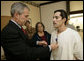 President George W. Bush presents the Purple Heart to U.S. Army Staff Sgt. Robert Cordero of El Paso, during a visit Friday, Dec. 22, 2006, to the Walter Reed Army Medical Center where the soldier is recovering from injuries suffered in Operation Iraqi Freedom. Looking on with Mrs. Laura Bush is Sgt. Cordero's mother, Rosa. White House photo by Eric Draper