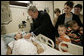 President George W. Bush presents a Purple Heart to Sgt. John Kriesel of Twin Cities, Minn., during a visit Friday, Dec. 22, 2006, to Walter Reed Army Medical Center where the National Guardsman is recovering from injuries suffered in Operation Iraqi Freedom. Looking on with Mrs. Laura Bush is Sgt. Kriesel's wife, Katie, holding their 4-year-old son Broden and 5-year-old son Elijah. White House photo by Eric Draper