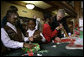 President George W. Bush helps young volunteers wrap presents for families of soldiers who were wounded in Iraq and Afghanistan, Friday, Dec. 22, 2006, at Walter Reed Army Medical Center in Washington, D.C. White House photo by Eric Draper