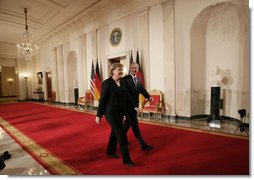 President George W. Bush and German Chancellor Angela Merkel leave Cross Hall at the White House, Thursday evening, Jan. 4, 2006, following their joint news conference.  White House photo by Paul Morse