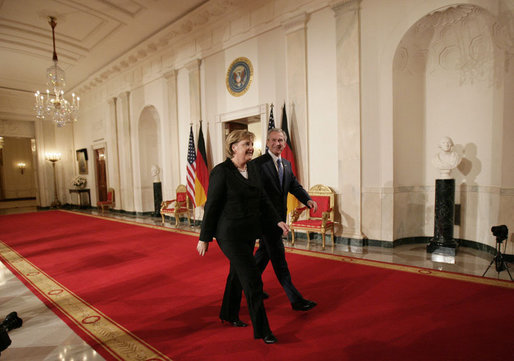 President George W. Bush and German Chancellor Angela Merkel leave Cross Hall at the White House, Thursday evening, Jan. 4, 2006, following their joint news conference. White House photo by Eric Draper