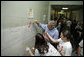 President George W. Bush lends a hand and his best brush strokes at Cardozo Senior High School in Washington, D.C., as volunteers spend Martin Luther King, Jr. Day painting murals of historical figures and local landmarks like the front of "Ben’s Chili Bowl" Monday, Jan. 15, 2007. White House photo by Paul Morse