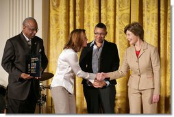 Mrs. Laura Bush presents Michelle Butler, left, and Alisa Lemon, center, of Studioworks, part of Communities in Schools in New Jersey, a Coming Up Taller Award during a ceremony in the East Room Monday, Jan. 22, 2007. James Farmer of PCAH is pictured at the far left. Each year, the Coming Up Taller Awards recognize and reward excellence in community arts and humanities programs for underserved children and youth. White House photo by Shealah Craighead