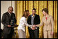 Mrs. Laura Bush presents Michelle Butler, left, and Alisa Lemon, center, of Studioworks, part of Communities in Schools in New Jersey, a Coming Up Taller Award during a ceremony in the East Room Monday, Jan. 22, 2007. James Farmer of PCAH is pictured at the far left. Each year, the Coming Up Taller Awards recognize and reward excellence in community arts and humanities programs for underserved children and youth. White House photo by Shealah Craighead