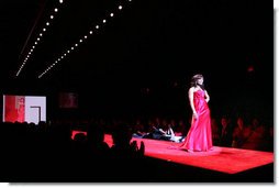 Mrs. Laura Bush and Joyce Cullen, a heart disease survivor, watch Angela Bassett model a red dress by Carmen Marc Valvo during the Red Dress Collection Celebrity Fashion Show at Bryant Park in New York, Friday, Feb. 2, 2007.  White House photo by Shealah Craighead