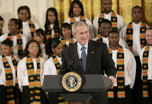 President George W. Bush, standing with members of the Jackson High School Black History Tour Group of Jackson, Mich., welcomes guests to the East Room of the White House, Monday, Feb. 12, 2007, during the celebration of African American History Month. White House photo by Eric Draper