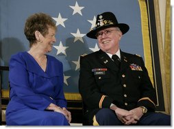 U.S. Army Major Bruce P. Crandall sits with his wife, Arlene, before a banner of the Medal of Honor in the East Room of the White House, Monday, Feb. 26, 2007, prior to Crandall being awarded the Medal of Honor for his extraordinary heroism as a 1st Cavalry helicopter flight commander in the Republic of Vietnam in November 1965. White House photo by Eric Draper