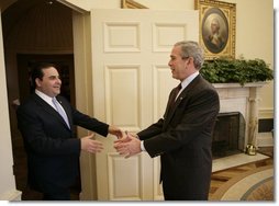 President George W. Bush reaches out to welcome President Elias Antonio Saca of El Salvador to the Oval Office Tuesday, Feb. 27, 2007. The leaders met for nearly an hour and discussed a number of topics, including an upcoming trade agreement between their countries, biofuels and the Millennium Challenge Account.  White House photo by Eric Draper