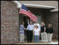 President George W. Bush shakes hands with Ernie Woodward of Long Beach, Miss. after Woodward, joined by his family, raised a flag given to them by President Bush outside his home Thursday, March 1, 2007, during the President’s tour of the neighborhood where some homes damaged by Hurricane Katrina have been rebuilt with Gulf Coast grant money. White House photo by Eric Draper