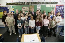 President George W. Bush is joined by Indiana Gov. Mitch Daniels, center, and Indiana Congressman Baron Hill, at left, as they pose for a photo with students and teachers Teri Sanders and Tammy Persinger in the fifth grade U.S. History class at the Silver Street Elementary School in New Albany, Ind., Friday, March 2, 2007.  White House photo by Eric Draper