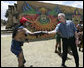 President George W. Bush reaches out to thank a performer Monday, March 12, 2007, after a demonstration of a Mayan Ritual competition at Iximche, Guatemala. White House photo by Eric Draper