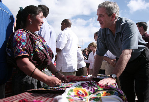 President George W. Bush talks with a vendor in the Town Square of Santa Cruz Balanya Monday, March 12, 2007, during a tour of the Guatemalan village. White House photo by Paul Morse