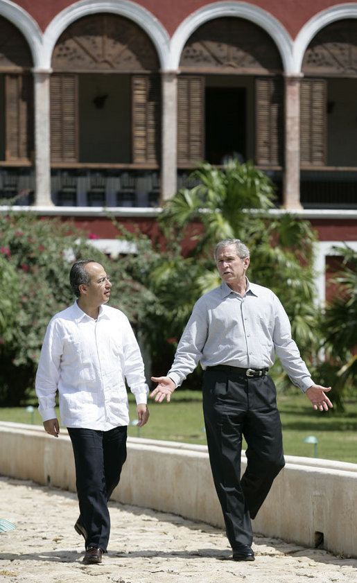 President George W. Bush and Mexico's President Felipe Calderon walk along a path Tuesday, March 13, 2007, en route to a meeting at the Hacienda Temozon in Temozon Sur, Mexico. The visit to the area marked the final leg of the President's five-country Latin American tour. White House photo by Eric Draper