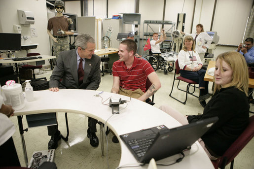 President George W. Bush talks with U.S. Army Cpl. Christopher Charles Strickland and his fiancee Amanda Jean Benoit, both of Waterford, Conn., Friday, March 30, 2007, during a visit to Walter Reed Army Medical Center in Washington, D.C. White House photo by Eric Draper