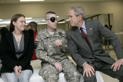 President George W. Bush talks with U.S. Army Sgt. Joel Robert Kalka and his girlfriend and caregiver, Amanda Sue Sink, both of Wailiku, Maui, Hawaii, Friday, March 30, 2007, during a visit to Walter Reed Army Medical Center in Washington, D.C. White House photo by Eric Draper