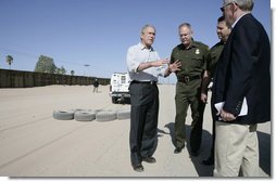 President George W. Bush emphasizes a point Monday, April 9, 2007, as he stands with Chief Border Patrol Agent Ron Colburn, center, and others during a tour of the U.S.-Mexico border in Yuma, Ariz. White House photo by Eric Draper