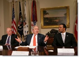 President George W. Bush gestures as he talks with reporters following a meeting on financial literacy Wednesday, April 25, 2007 in the Roosevelt Room at the White House, where President Bush said he has directed U.S. Secretary of the Treasury Henry Paulson, left, to develop and hone a strategy that will help more of our American citizens to become financially literate.John Bryant, president and CEO of Operation Hope, is seen at right.  White House photo by Eric Draper