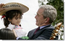 President George W. Bush embraces Angelica Mora Arriaga, a member of the Los Hermanos Mora Arriaga mariachi band, in the Rose Garden at the White House Friday, May 4, 2007, to celebrate Cinco de Mayo. White House photo by Eric Draper