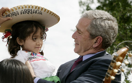 President George W. Bush embraces Angelica Mora Arriaga, a member of the Los Hermanos Mora Arriaga mariachi band, in the Rose Garden at the White House Friday, May 4, 2007, to celebrate Cinco de Mayo. White House photo by Eric Draper