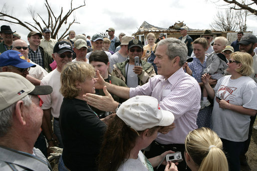 President George W. Bush reaches out to a woman as he tours a neighborhood Wednesday, May 9, 2007, in Greensburg, Kansas. The town of 1,600 people more than 90 percent of its homes and businesses in a deadly tornado last Friday, and the President toured the destruction and offered comfort to the community during his visit. White House photo by Eric Draper