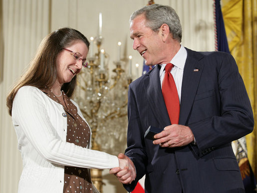 President George W. Bush congratulates military spouse Linda Port of Langley Air Force Base, Va., as she is presented with the President’s Volunteer Service Award Friday, May 11, 2007, in the East Room of the White House during a celebration of Military Spouse Day. White House photo by Eric Draper