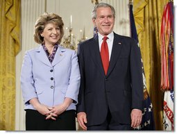 President George W. Bush joins military spouse Denise Rampolla of Cheyenne, Wyo., on stage in the East Room of the White House, to receive the President’s Volunteer Service Award Friday, May 11, 2007, during a commemoration of Military Spouse Day. White House photo by Eric Draper