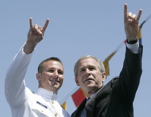 President George W. Bush and U.S. Coast Guard graduate Brian Robert Staudt offer the Texas Longhorns hand sign out to the audience following the President’s address to the graduates Wednesday, May 23, 2007, at the U.S. Coast Guard Academy commencement in New London, Conn. White House photo by Joyce Boghosian