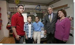 President George W. Bush stands with Cpl. Manuel Provencio of Tucson, after awarding him a Purple Heart Friday, May 25, 2007, during a visit to the National Naval Medical Center in Bethesda, Md., where the Marine is recovering from wounds received in Operation Iraqi Freedom. With them are Cpl. Provencio's mother, Manuela, and brothers, Carlos, in red, and Angel.  White House photo by Joyce N. Boghosian