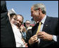 President George W. Bush greets a young child as he signs autographs following his speech Tuesday, June 12, 2007, at the dedication ceremony for the Victims of Communism Memorial in Washington, D.C. White House photo by Joyce N. Boghosian