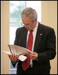 President George W. Bush reads the Report to the President on Issues Raised by the Virginia Tech Tragedy in the Oval Office Wednesday, June 13, 2007. The report, presented to President Bush Wednesday afternoon, was compiled by the departments of Justice, Health and Human Services and Education in response to the tragic shooting rampage at Virginia Tech April 16, 2007 in Blacksburg, Va. White House photo by Eric Draper