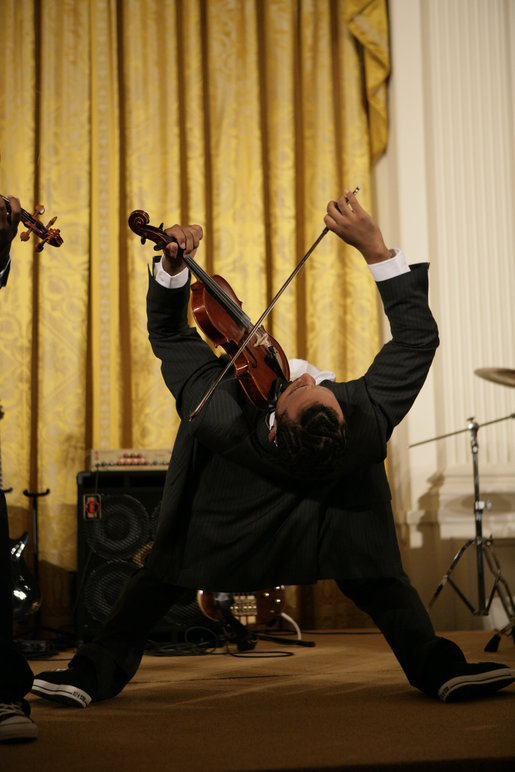 Violinist Tourie Escobar arches back almost to the floor as he performs with his brother Damein for President George W. Bush and guests Friday, June 22, 2007 in the East Room of the White House, in celebration of Black Music Month. White House photo by Eric Draper