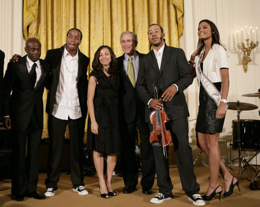 President George W. Bush thanks entertainers, from left to right, KEM, Tourie Escobar, Karina Pasian, Damien Escobar and Miss USA Rachel Smith on stage Friday, June 22, 2007 in the East Room of the White House, for their participation in a celebration of Black Music Month at the White House. White House photo by Eric Draper