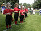 Members of the Luray, Virginia Red Wings hold their caps over their hearts during the playing of the national anthem Wednesday, June 27, 2007, prior to the start of the 2007 White House Tee Ball opener against the Bobcats of Cumberland, Maryland. White House photo by Eric Draper