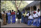 Mrs. Laura Bush walks with Zambian First Lady Mrs. Maureen Manawasa, center right, Thursday, June 28, 2007, at the Flame Community Center in Lusaka, Zambia. They are greeted in song by members of the WORTH Tufune Women's Group. The WORTH group trains women in literacy, group savings, peer lending and the development of small business. White House photo by Shealah Craighead