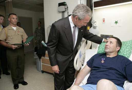 As a Military Aide to the President reads the citation, President George W. Bush honors Sgt. 1st Class Andy Allen with a Purple Heart Tuesday, July 3, 2007, during a visit to Walter Reed Army Medical Center in Washington, D.C., where the Elk City, O.K., soldier is recovering from wounds received in Operation Iraqi Freedom. White House photo by Eric Draper