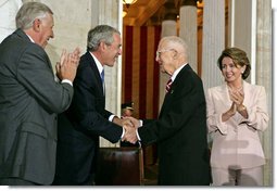 President George W. Bush congratulates Dr. Norman Bourlag during the Congressional Gold Medal Ceremony honoring the doctor's efforts to combat hunger Tuesday, July 17 , 2007, at the U.S. Capitol. Also pictured is House Majority Leader Steny Hoyer, left, and Speaker of the House Nancy Pelosi. White House photo by Chris Greenberg