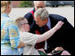 President George W. Bush embraces Army National Guard Sgt. James Kevin Downs of Kingston Springs, Tenn., on his arrival Thursday, July 19, 2007 to Nashville International Airport. President Bush first met Sgt. Downs, seen with his parents, at the Brooke Army Medical Center in January 2006, where Downs was recovering from severe injuries caused during a bomb and rocket attack in Iraq in August 2005. White House photo by Chris Greenberg