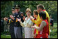 Mrs. Laura Bush and her fellow stage participates applaud runner Karen Dickerson of Springfield, Va., during a Special Olympics Global Law Enforcement Torch Run Ceremony Thursday, July 26, 2007, in the Rose Garden. "Karen is a tireless advocate for her fellow athletes. She's what we call a fierce competitor," said the President in his remarks. "In the 2003 World Games in Ireland, Karen was told that she had a stress fracture in her leg. Yet, through sheer willpower, she won the Bronze Medal." White House photo by Eric Draper