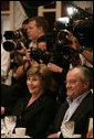 Mrs. Laura Bush and fellow dinner guest Joe Canizaro, president and CEO of Columbus Properties of New Orleans, are backed by news cameras during a dinner with Louisiana cultural and community leaders Tuesday evening, Aug. 28, 2007, at Dooky Chase's restaurant in New Orleans. President George W. Bush and Mrs. Laura Bush are visiting New Orleans and the Gulf Coast region on the second anniversary of Hurricane Katrina. White House photo by Shealah Craighead