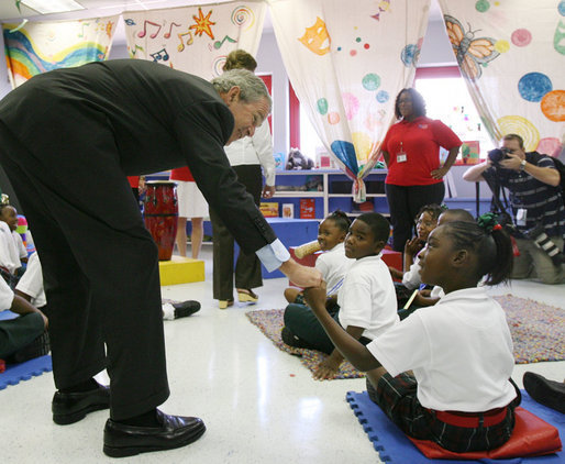 President George W. Bush reaches down to greet a student at the Dr. Martin Luther King Jr. Charter School for Science and Technology Wednesday, Aug. 29, 2007, in New Orleans, during his visit to New Orleans and the Gulf Coast region on the second anniversary of Hurricane Katrina. White House photo by Shealah Craighead