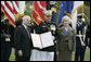 Outgoing Joint Chiefs of Staff Chairman U.S. Marine General Peter Pace, joined by his wife, Lynne Pace, right, receives his official certificate of retirement from the U.S. Marine Corps from U.S. Secretary of Defense Robert Gates, during the Armed Forces farewell tribute in honor of General Pace and the Armed Forces hail in honor of the new Joint Chiefs of Staff Chairman Navy Admiral Michael Mullen, Monday, October 1, 2007 at Fort Myer, Virginia. White House photo by Eric Draper