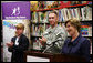 Mrs. Laura Bush is applauded during her address to students, faculty and guests at the Good Shepherd Nativity Mission School, Thursday, Nov. 1, 2007 in New Orleans, during a Helping America's Youth visit with Big Brother and Big Sisters of Southeast Louisiana. Mrs. Bush spoke about the importance of adults as positive role models in young children's lives. Student Taylor McIntyre is seen at left, joined by his Big Brother Captain Richard T. Douget. White House photo by Shealah Craighead