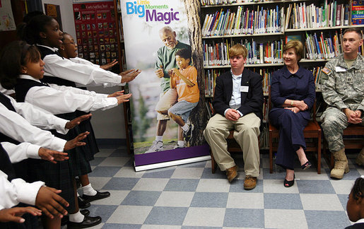 Mrs. Laura Bush listens to the student choir perform at the Good Shepherd Nativity Mission School, Thursday, Nov. 1, 2007 in New Orleans, during a Helping America's Youth visit with Big Brothers and Big Sisters of Southeast Louisiana. Mrs. Bush is joined by student Taylor McIntyre, left, and his Big Brother Captain Richard T. Douget. White House photo by Shealah Craighead