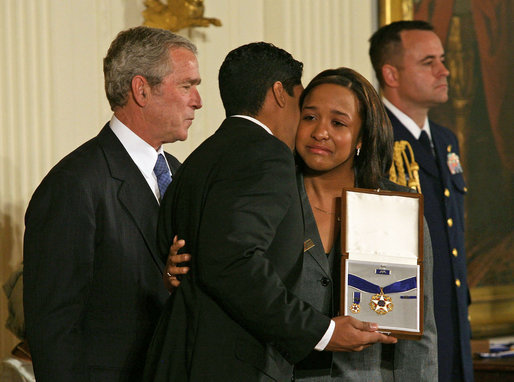 President George W. Bush presents the Presidential Medal of Freedom to Yan Valdes Morejon and Winnie Biscet in honor of their father Oscar Elias Biscet during a ceremony Monday, Nov. 5, 2007, in the East Room. "Oscar Biscet is a healer -- known to 11 million Cubans as a physician, a community organizer, and an advocate for human rights," said the President about the imprisoned physician. "The international community agrees that Dr. Biscet's imprisonment is unjust, yet the regime has refused every call for his release." White House photo by Joyce N. Boghosian