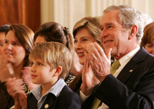 President George W. Bush and Mrs. Laura Bush are joined by Elijah Atkins, Friday, Nov. 16, 2007 in the East Room of the White House, as they listen to Atkins' father, country music star Rodney Atkins, performing for guests during the celebration of National Adoption Day. Rodney Atkins is the 2007-2008 national celebrity spokesperson for The National Council for Adoption. White House photo by Chris Greenberg